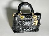 a small black purse with a gold chain on it