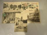 quelques vieilles cartes postales représentant des bâtiments anciens et une statue, posées sur une table