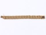 a close up of a gold chain bracelet on a white background