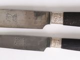 two knives that are sitting on a white surface