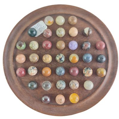 une assiette en bois sur laquelle sont disposées de nombreuses billes