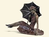 a statue of a woman with an umbrella sitting on the ground