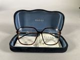 gucci eyeglasses in a case on a white surface