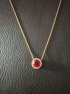 un collier orné d'une pierre rouge sur un fond en cuir noir