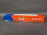 an orange and blue box of toothpaste sitting on a gray surface