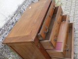 une commode en bois avec deux tiroirs, dont un rose