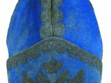 chapeau bleu et noir orné d'un oiseau sur fond blanc