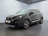 La voiture noire est garée dans une grande pièce aux murs blancs.