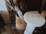 une statue représentant une femme assise sur un tabouret à côté d'un tonneau en bois