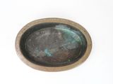 a small metal bowl with a brown rim on a white surface
