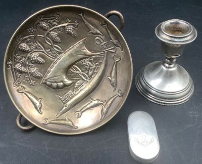 a silver plate with a bird on it next to a candle holder