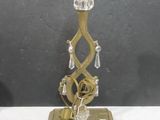 a gold candle holder with a glass candle on it