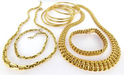 several pieces of gold jewelry on a white surface