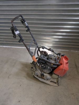 an image of a small lawn mower in front of a garage door