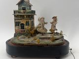 a figurine of a man and a woman in front of a house
