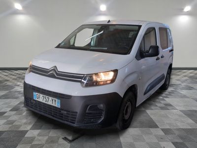 la camionnette blanche est garée sur un sol en damier dans le garage