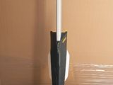 a yellow and black mop sitting on the floor next to a cardboard box