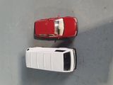 two toy cars sitting next to each other on the floor