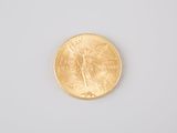 a close up of a gold coin on a white surface