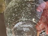 a person holding a glass with a piece of meat inside of it