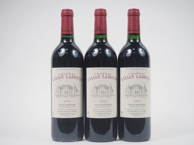 trois bouteilles de vin rouge posées l'une à côté de l'autre sur une surface blanche