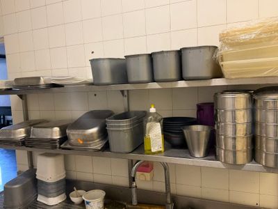 de nombreuses casseroles et poêles sur les étagères de la cuisine