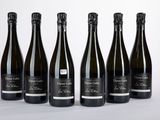 six bouteilles de vin alignées sur une table