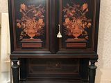a black cabinet with flowers on it in a room