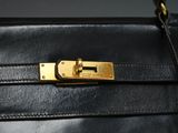 a close up of a black purse with a gold lock on it
