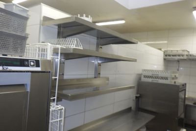étagères dans une cuisine professionnelle équipée d'un lave-vaisselle et d'un lave-vaisselle