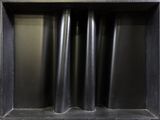 a black shelf with three black vases in it