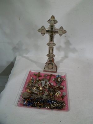 une croix sur une table avec beaucoup de bijoux dessus