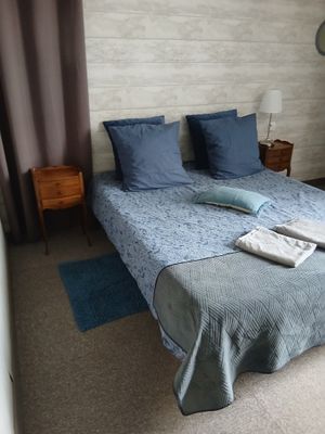 un lit sur lequel sont posés une couette bleue et deux oreillers