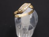 un gros plan d'une bague en or sertie d'un diamant posée sur un verre transparent