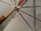 a close up of a umbrella with a wooden handle