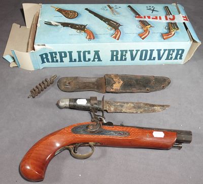 une boîte contenant un pistolet, un couteau et d'autres objets, posée sur la table
