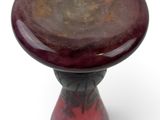 a red and black stool sitting on a white surface