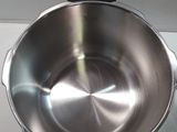 a large metal pan with a handle on a counter