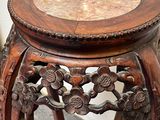 a small wooden table with a marble top on it