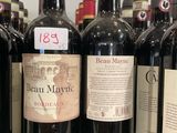 plusieurs bouteilles de vin rouge sont alignées sur une étagère