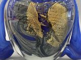 a blue vase with a gold leaf inside of it