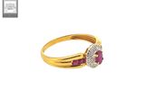 a close up of a gold ring with a ruby and diamond center