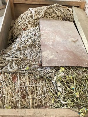une caisse en bois remplie de beaucoup de corde et d'autres objets