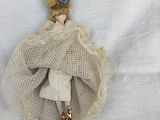 a doll that is laying down on a white sheet