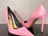 a pair of pink high heels on a black surface