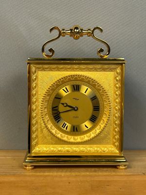 une horloge en or posée sur une table en bois