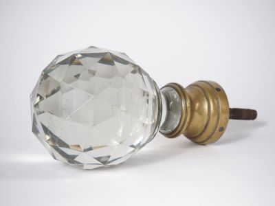 une poignée de porte en verre avec une poignée dorée sur fond blanc