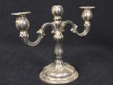 an antique silver plated candelab with two candles on a stand