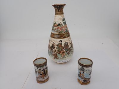 un vase et deux tasses posés sur une table