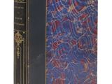 un vieux livre à la couverture bleue posé sur une surface blanche